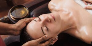 ayurvedic-face-massage-with-oil-on-the-wooden-table-fotolia